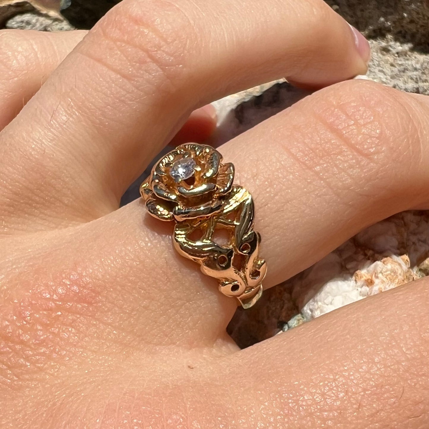 A ladies' yellow gold rose style ring set with a natural 0.10ct diamond.