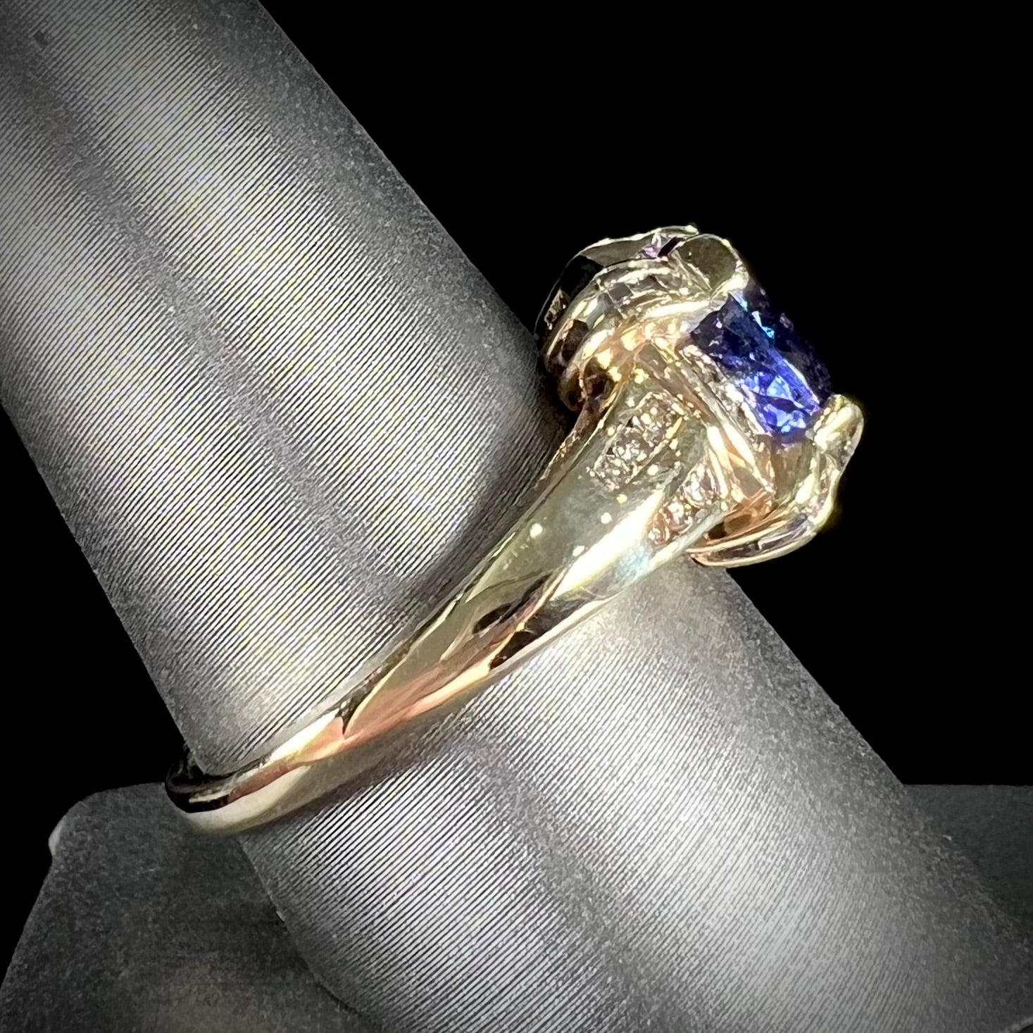 A ladies' yellow gold natural tanzanite and diamond ring.  Diamonds are channel set along the shank and in the prongs.