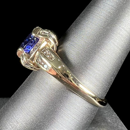 A ladies' yellow gold natural tanzanite and diamond ring.  Diamonds are channel set along the shank and in the prongs.