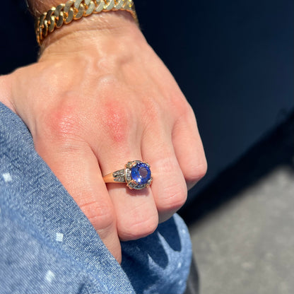 A ladies' yellow gold natural tanzanite and diamond ring.  Diamonds are channel set along the shank and in the prongs.