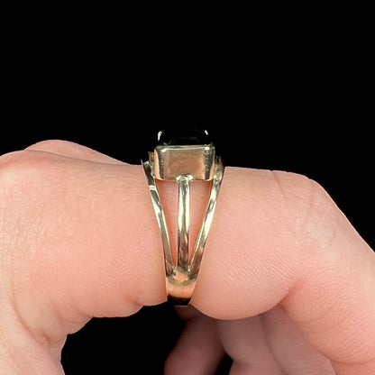 A men's emerald cut tricolor tourmaline solitaire ring in yellow gold.  The tourmaline shifts from green to blue green to blue.