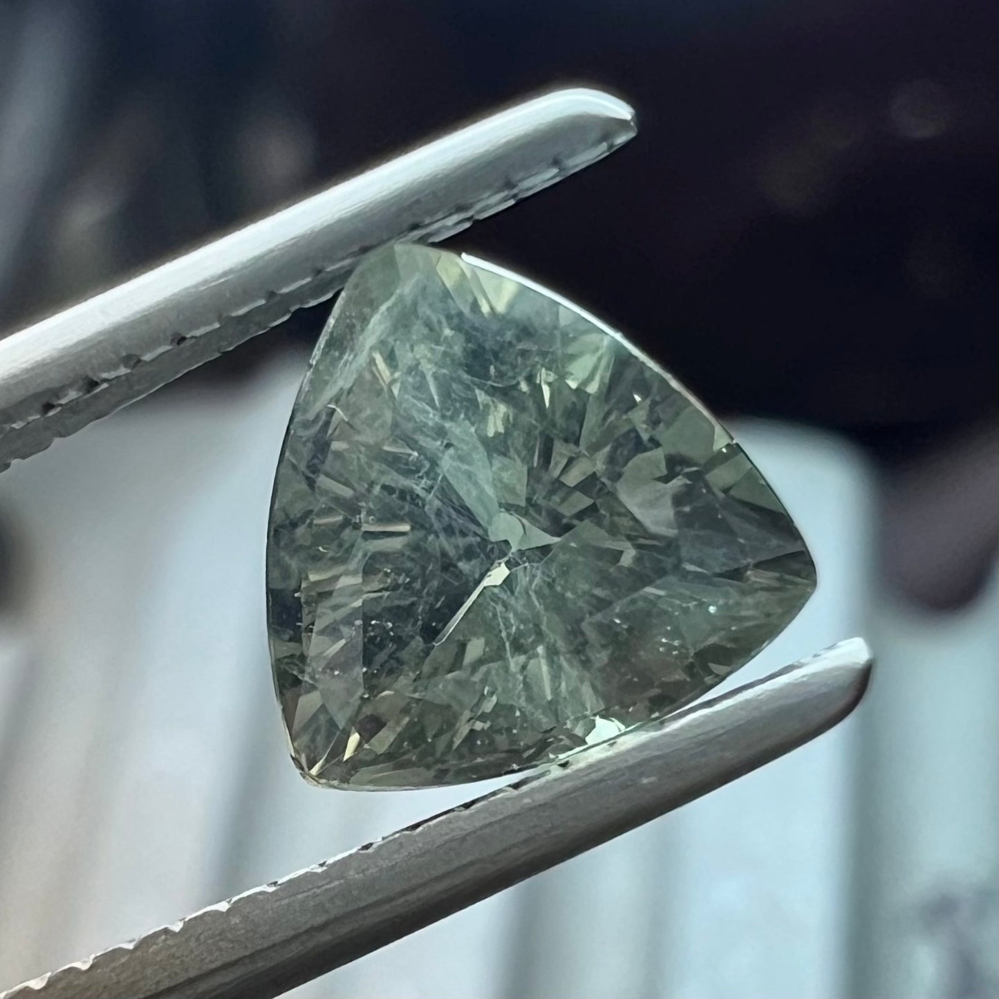 A natural, 1.10 carat, trillion cut alexandrite gemstone.  The stone changes colors from dark olive green to faint purplish green.