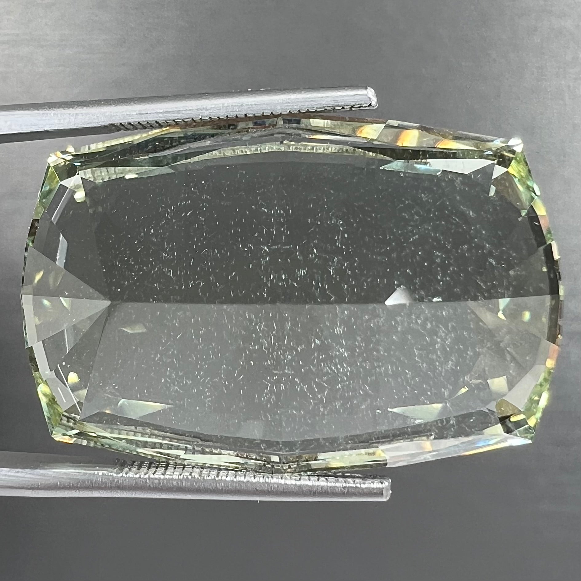 A loose, modified cushion cut heliodor beryl gemstone.  The stone is a yellow-green color.