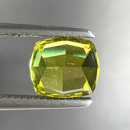 A loose, modified cushion cut greenish yellow chrysoberyl gemstone.