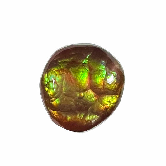 An iridescent green, yellow, and red Mexican fire agate stone.  The stone is an off-round cabochon.