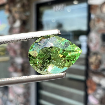 A loose, pear shaped tsavorite garnet gemstone.  The stone is yellowish green.