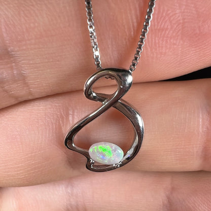 A ladies' sterling silver necklace set with an oval cabochon cut natural white crystal opal with green fire.