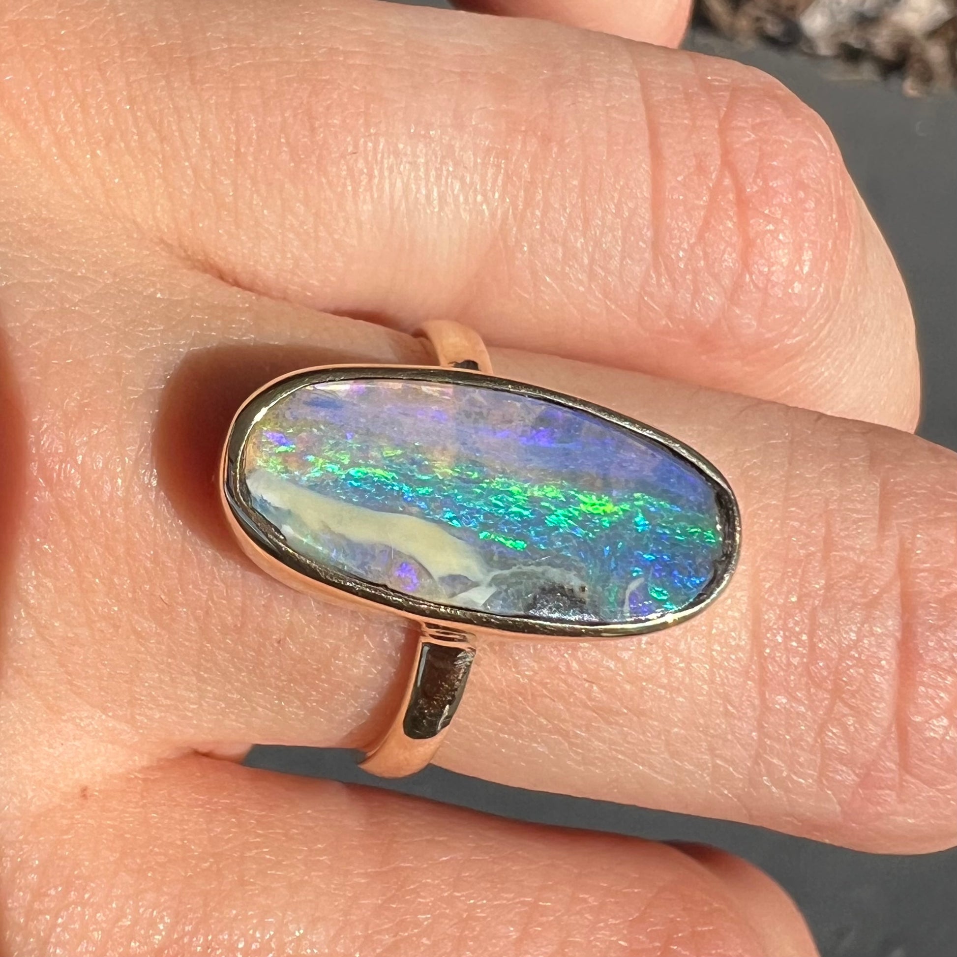 Ladies' yellow gold solitaire ring bezel set with a natural green striped boulder opal from Quilpie, Australia.