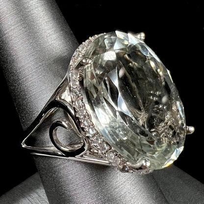 A ladies' green quartz and white zircon accented halo sterling silver cocktail ring.
