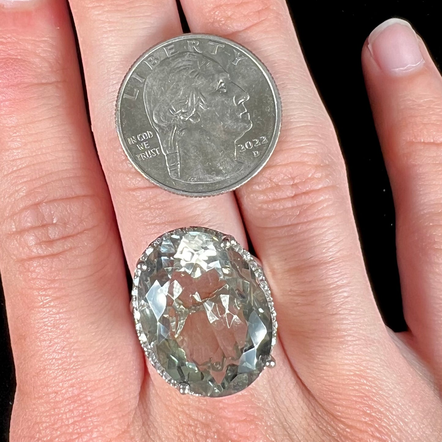 A ladies' green quartz and white zircon accented halo sterling silver cocktail ring.