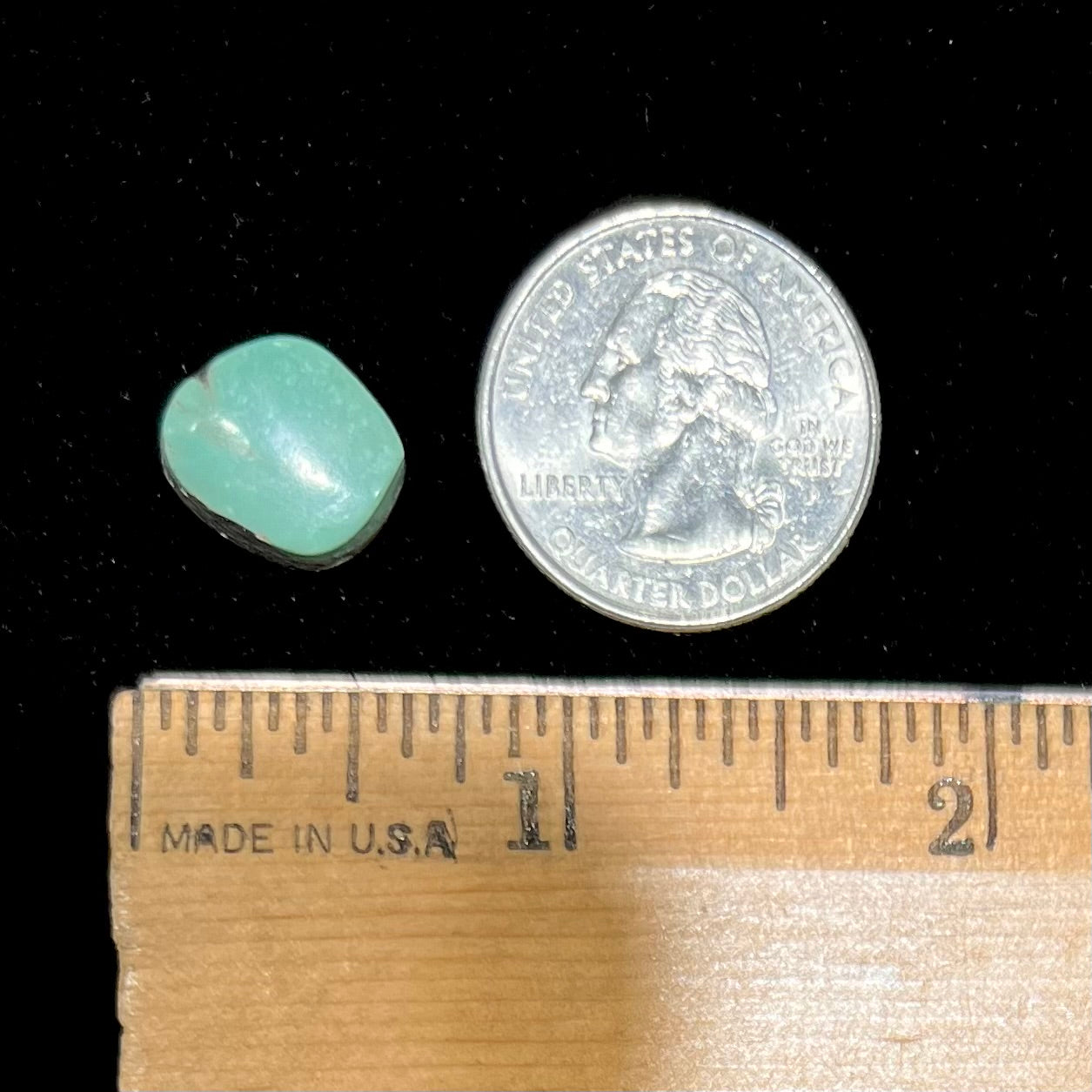 A backed, freeform cabochon cut dark green turquoise stone from Royston Mining District, Nevada.