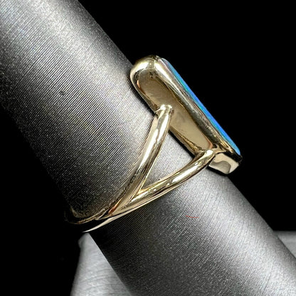 A ladies' split shank gold ring bezel set with a natural, Australian black boulder opal.