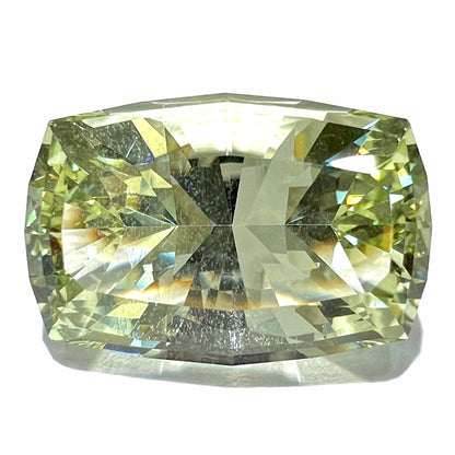 A loose, modified cushion cut heliodor beryl gemstone.  The stone is a yellow-green color and weighs 31.28 carats.