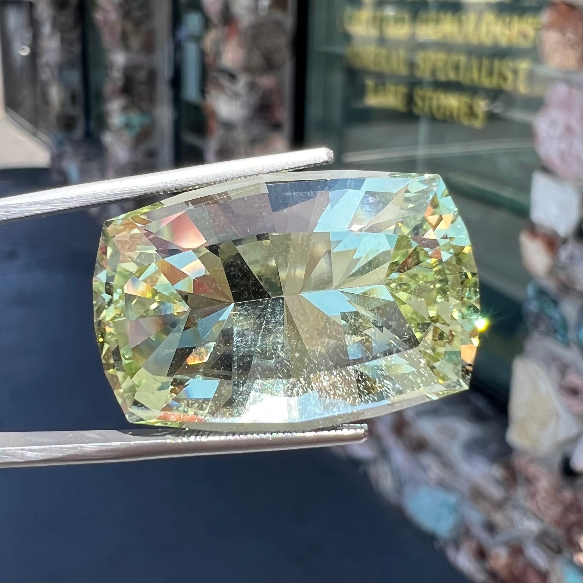 A loose, modified cushion cut heliodor beryl gemstone.  The stone is a yellow-green color.