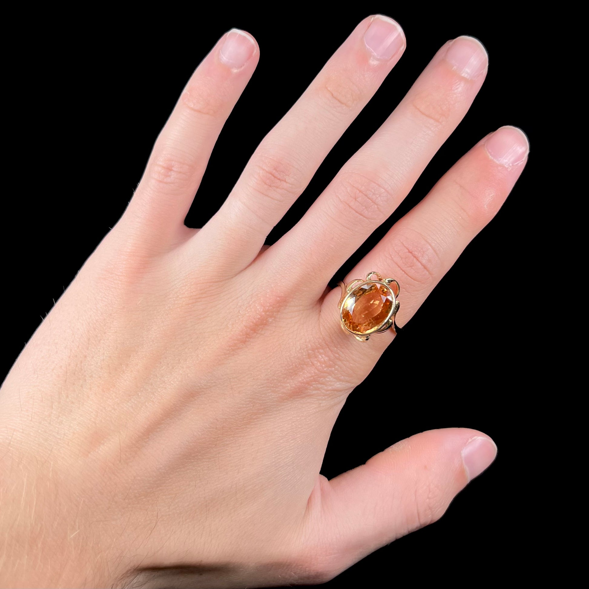 A ladies' yellow gold solitaire ring set with an 8.00 carat oval cut orange hessonite garnet.