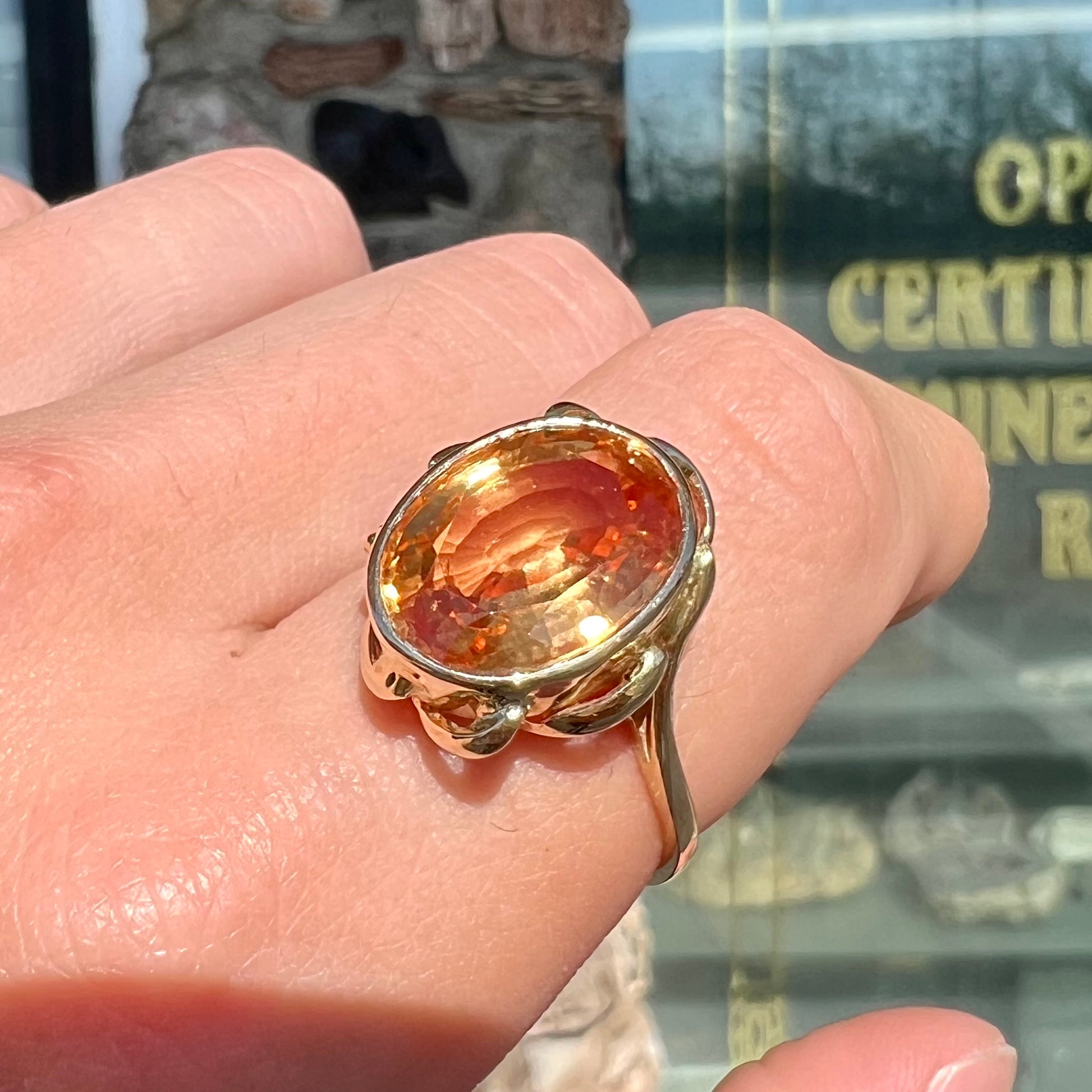 A ladies' yellow gold solitaire ring set with an 8.00 carat oval cut orange hessonite garnet.