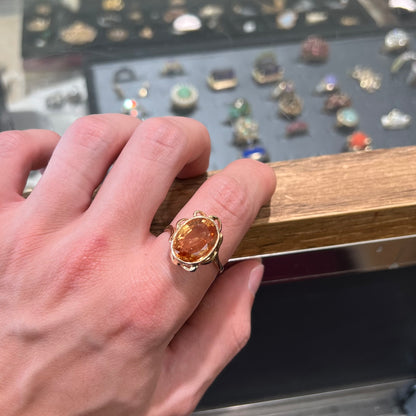 A ladies' yellow gold solitaire ring set with an 8.00 carat oval cut orange hessonite garnet.