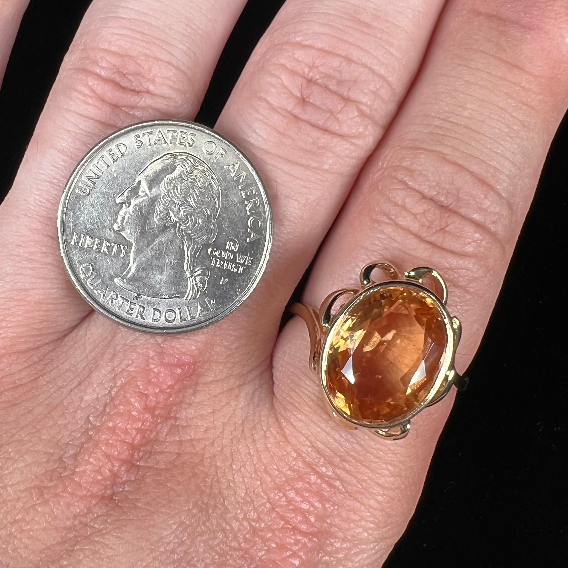 A ladies' yellow gold solitaire ring set with an 8.00 carat oval cut orange hessonite garnet.