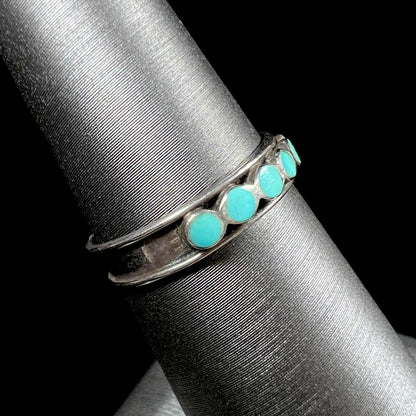 A ladies' sterling silver Hopi style band set with round cut Sleeping Beauty turquoise stones.