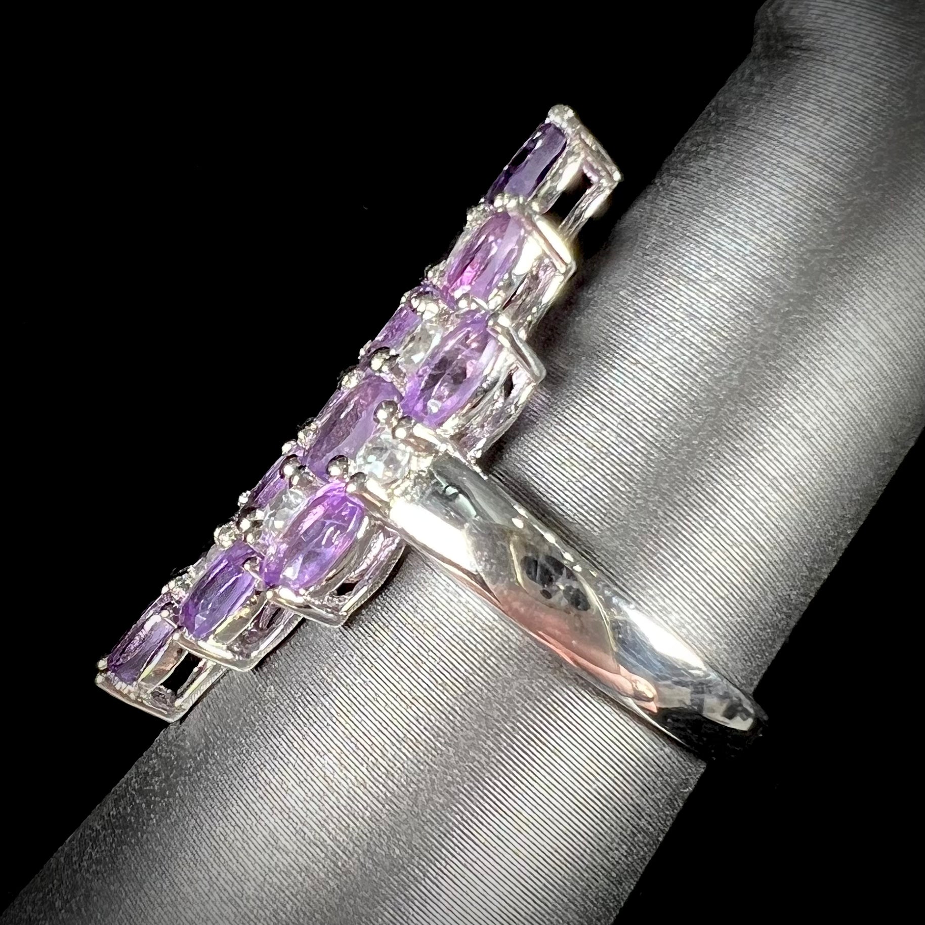 A ladies' modern style sterling silver amethyst and cubic zirconia cluster ring.