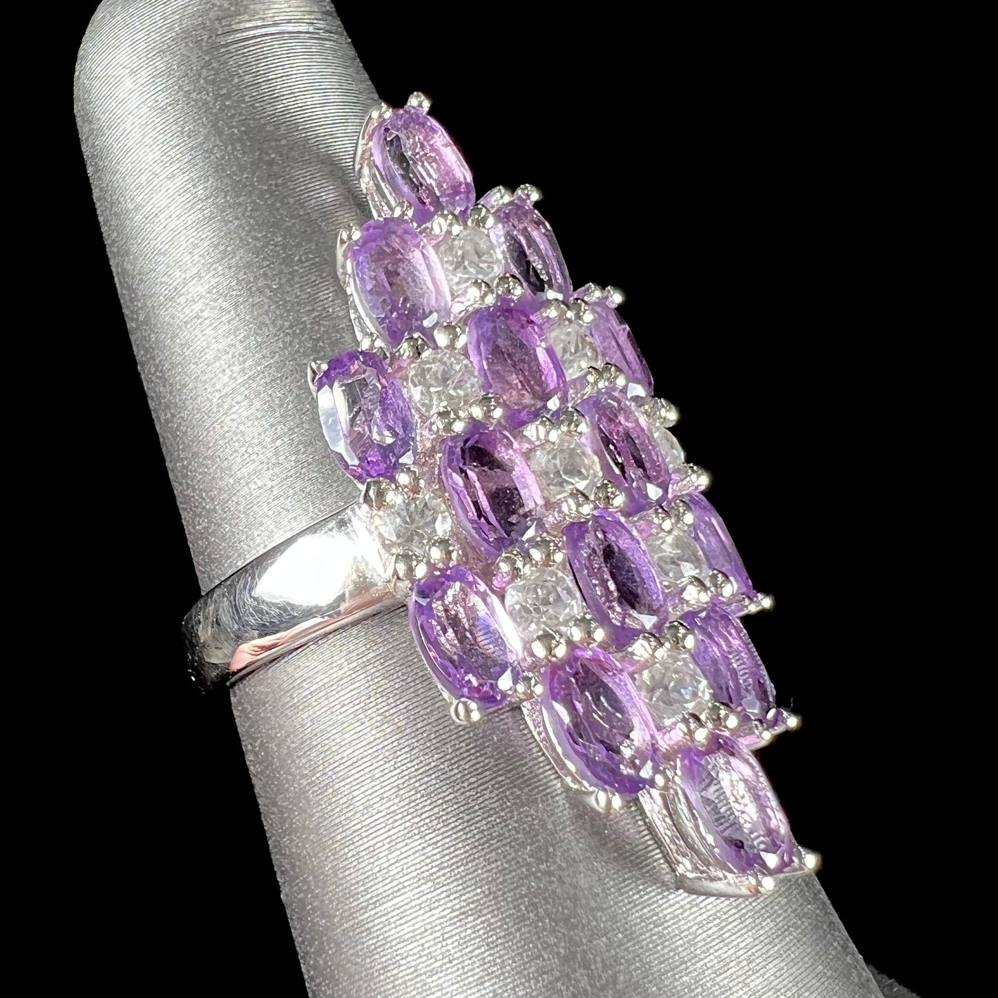 A ladies' modern style sterling silver amethyst and cubic zirconia cluster ring.