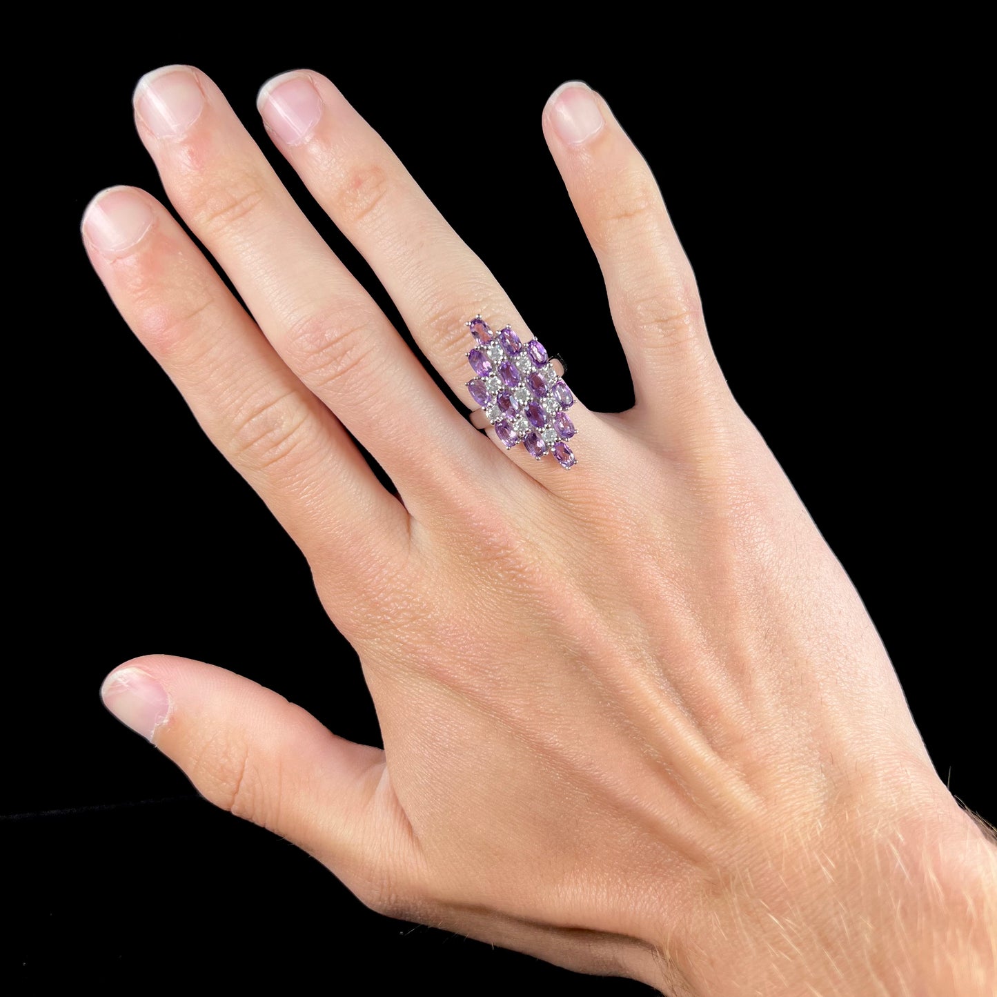 A ladies' modern style sterling silver amethyst and cubic zirconia cluster ring.