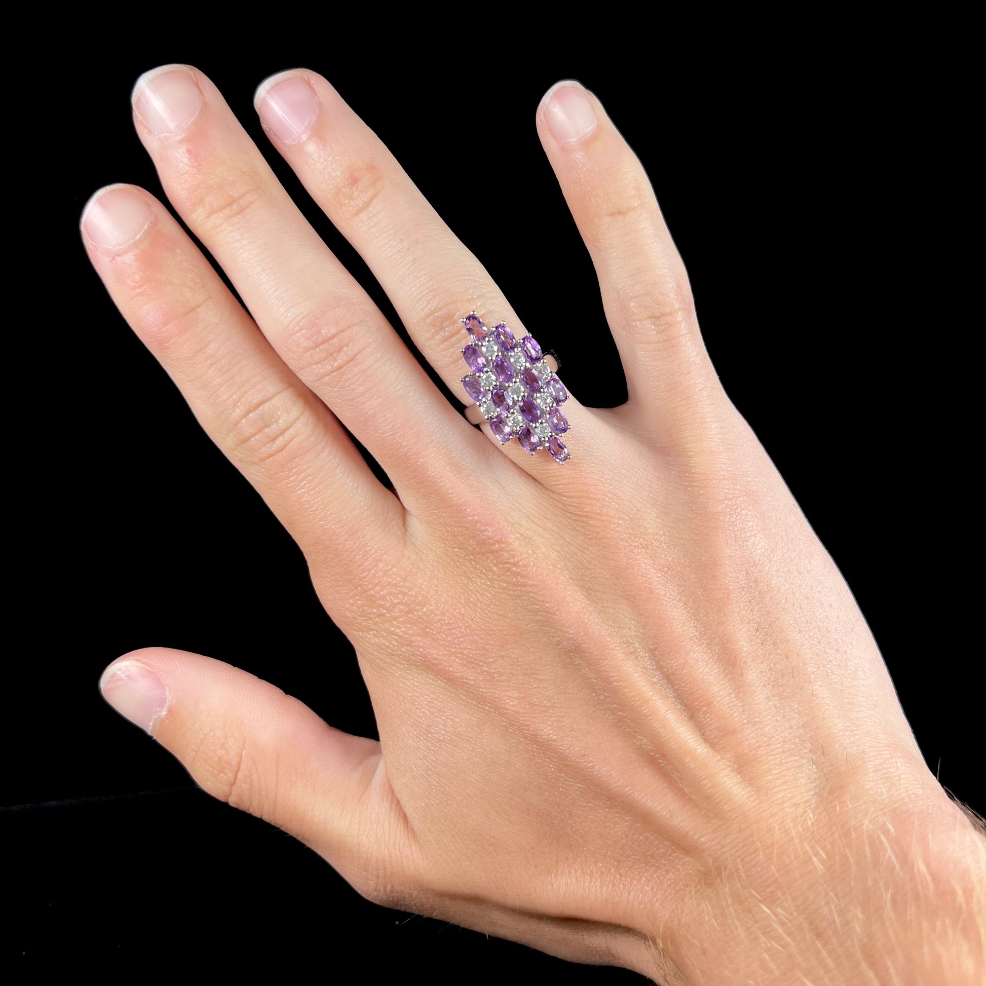 A ladies' modern style sterling silver amethyst and cubic zirconia cluster ring.