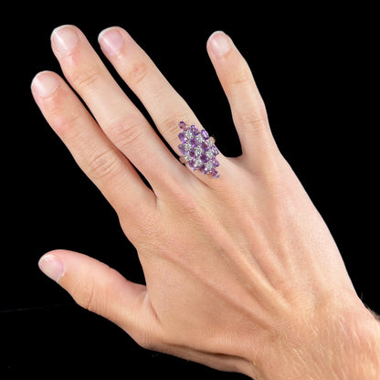 A ladies' modern style sterling silver amethyst and cubic zirconia cluster ring.