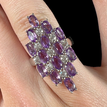 A ladies' modern style sterling silver amethyst and cubic zirconia cluster ring.