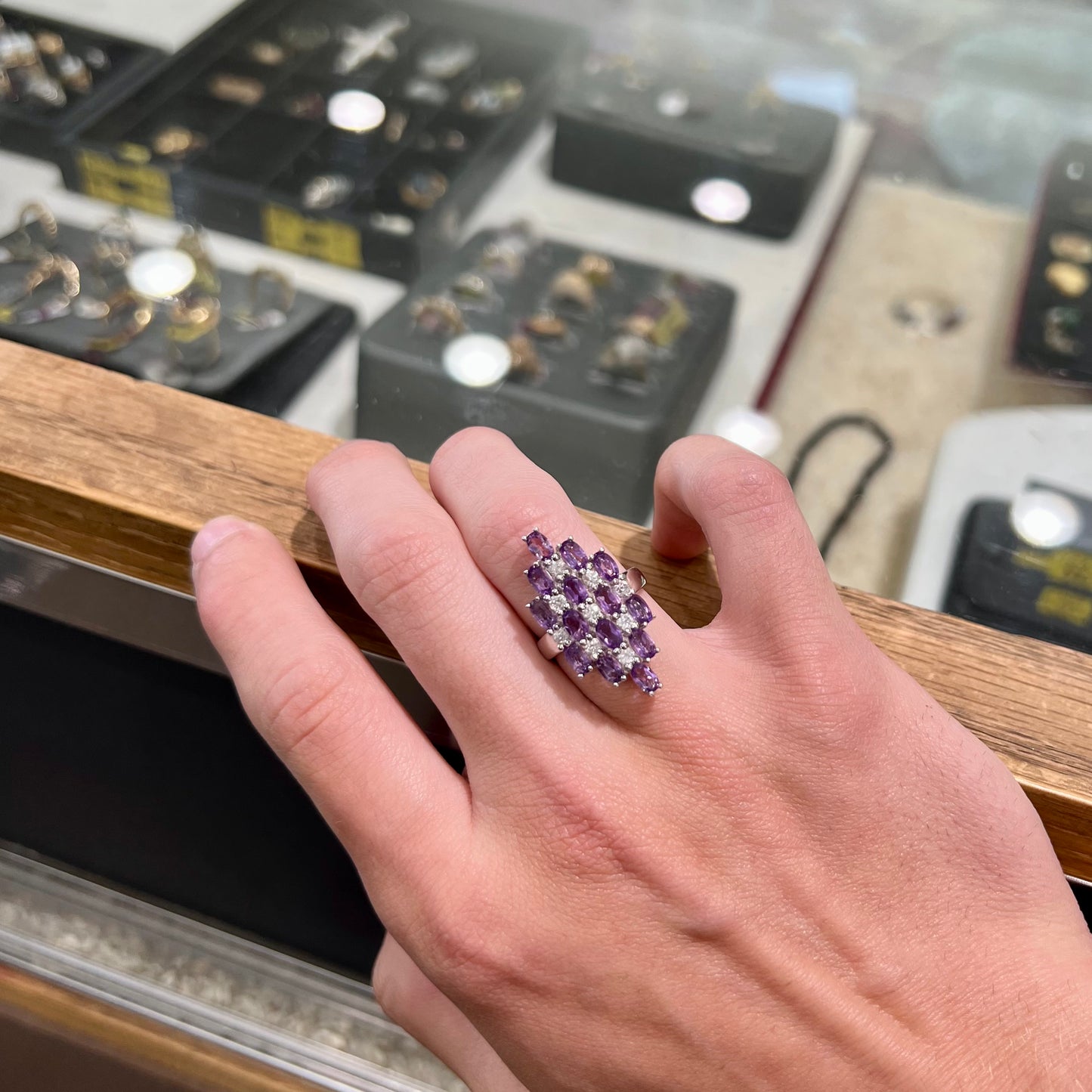 A ladies' modern style sterling silver amethyst and cubic zirconia cluster ring.