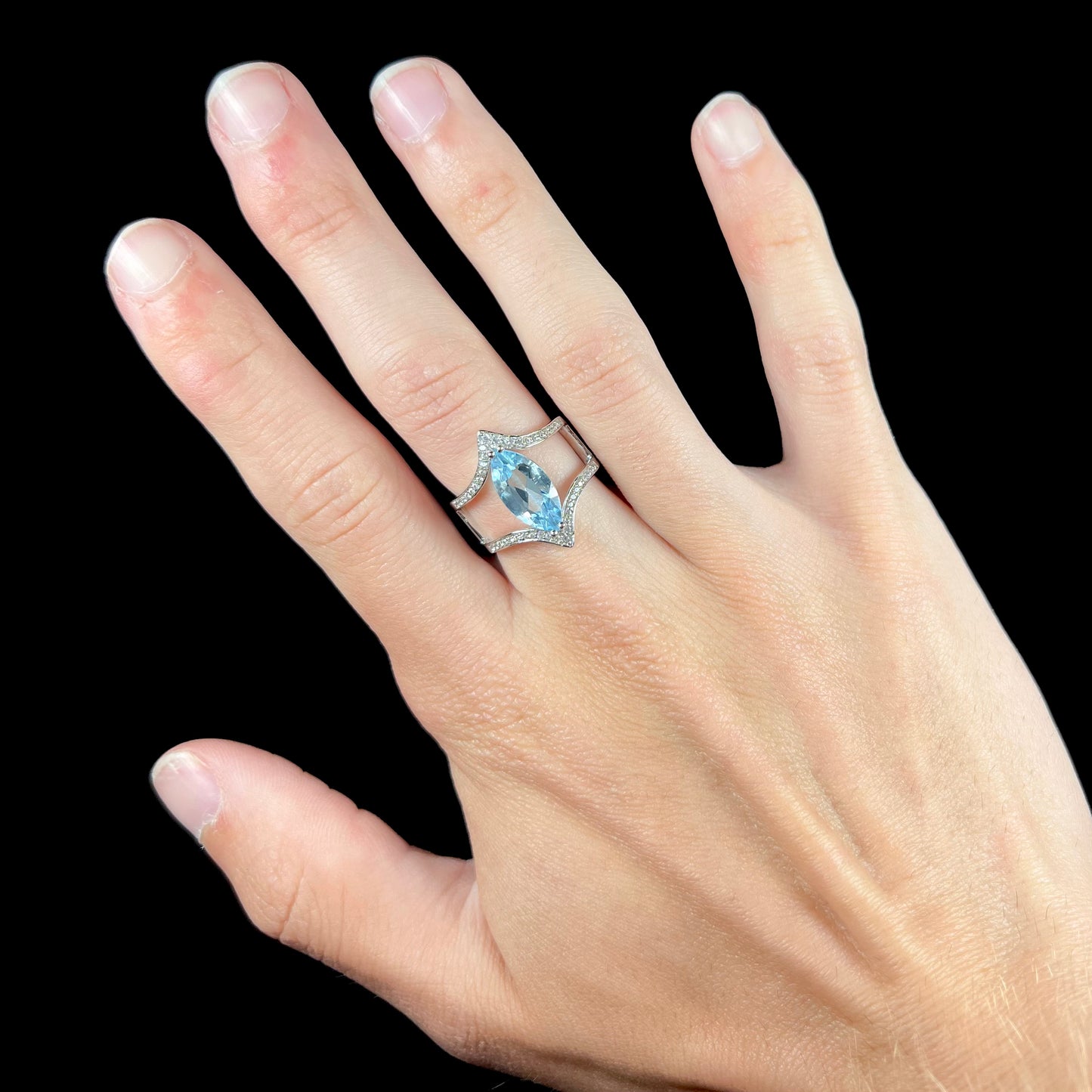A ladies' marquise cut blue topaz and cubic zirconia accented ring cast in sterling silver.