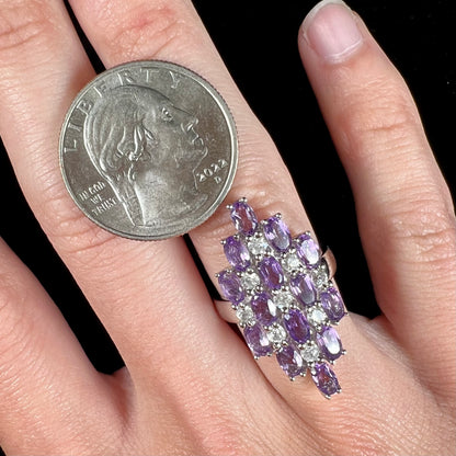 A ladies' modern style sterling silver amethyst and cubic zirconia cluster ring.