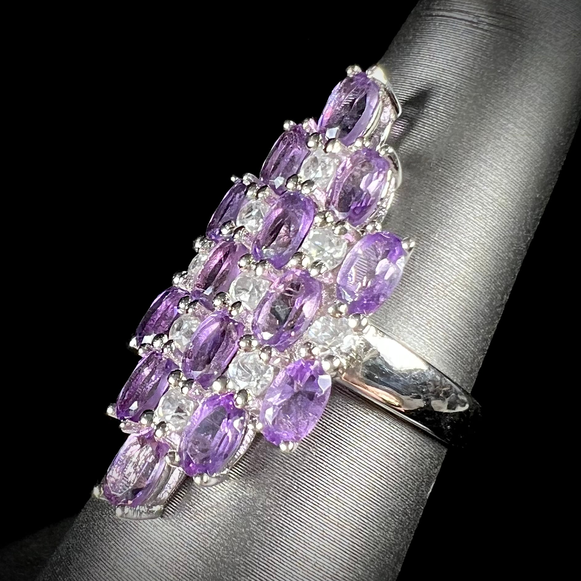 A ladies' modern style sterling silver amethyst and cubic zirconia cluster ring.