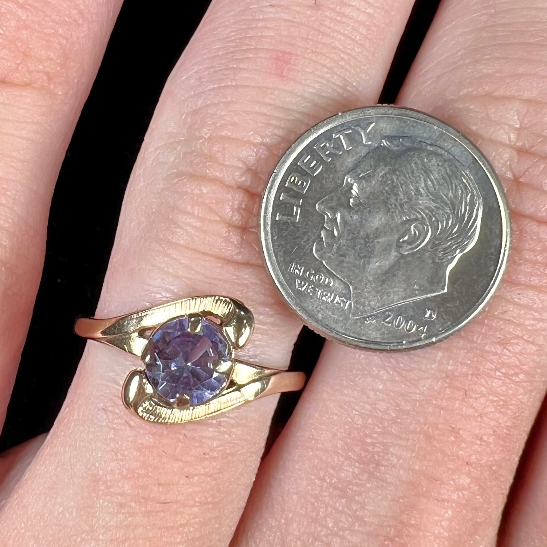 A vintage 1960's yellow gold ring set with a round synthetic purple alexandrite.  The prongs are worn.