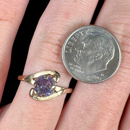 A vintage 1960's yellow gold ring set with a round synthetic purple alexandrite.  The prongs are worn.