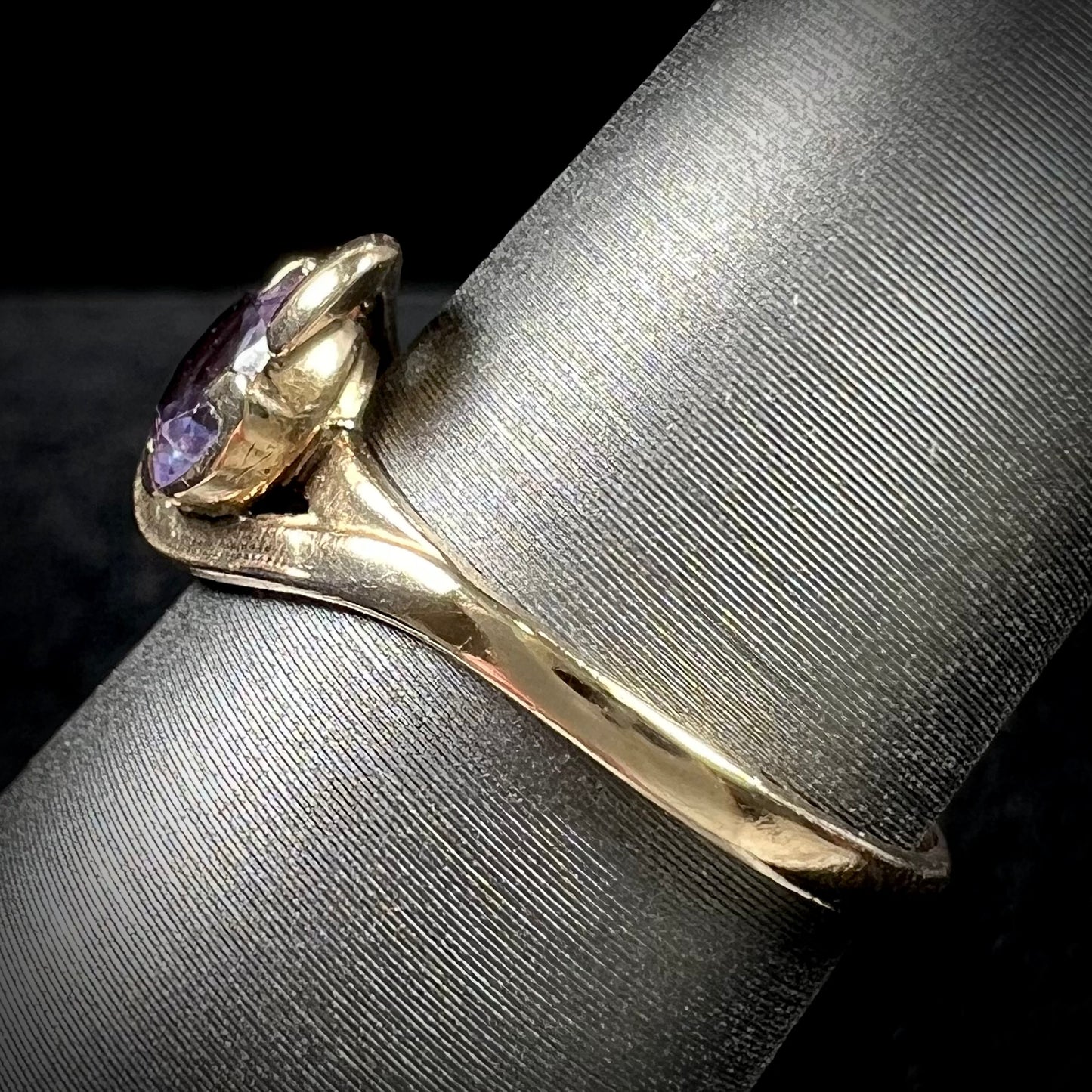 A vintage 1960's yellow gold ring set with a round synthetic purple alexandrite.  The prongs are worn.