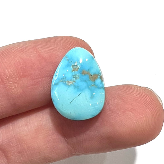 A loose, drop shaped, cabochon cut Sleeping Beauty turquoise stone.