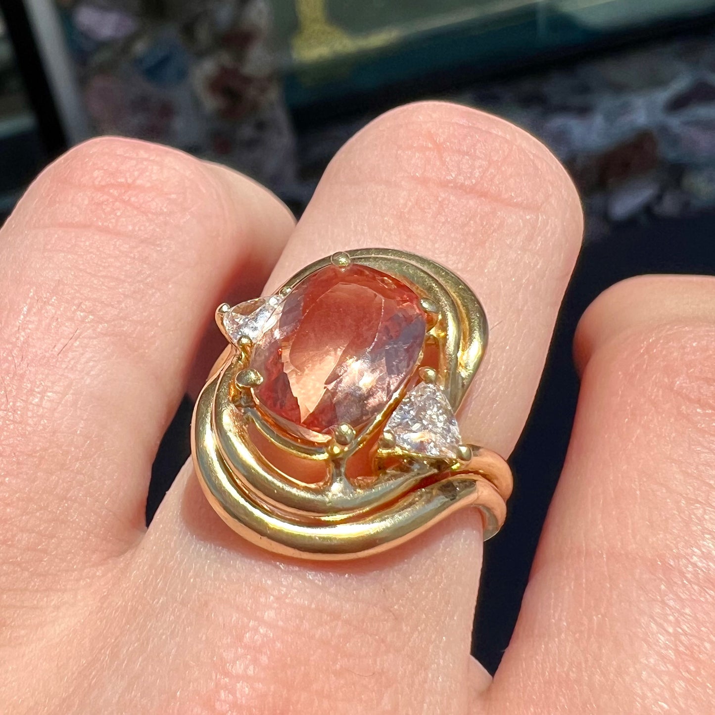An 18 karat yellow gold ring set with two triangle cut diamonds and a cushion cut imperial topaz.