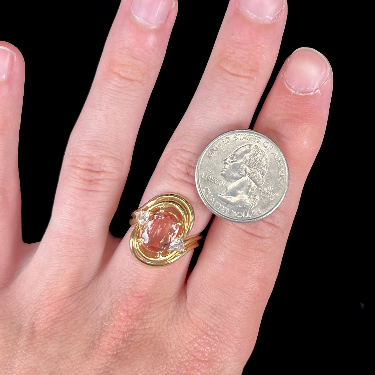 An 18 karat yellow gold ring set with two triangle cut diamonds and a cushion cut imperial topaz.