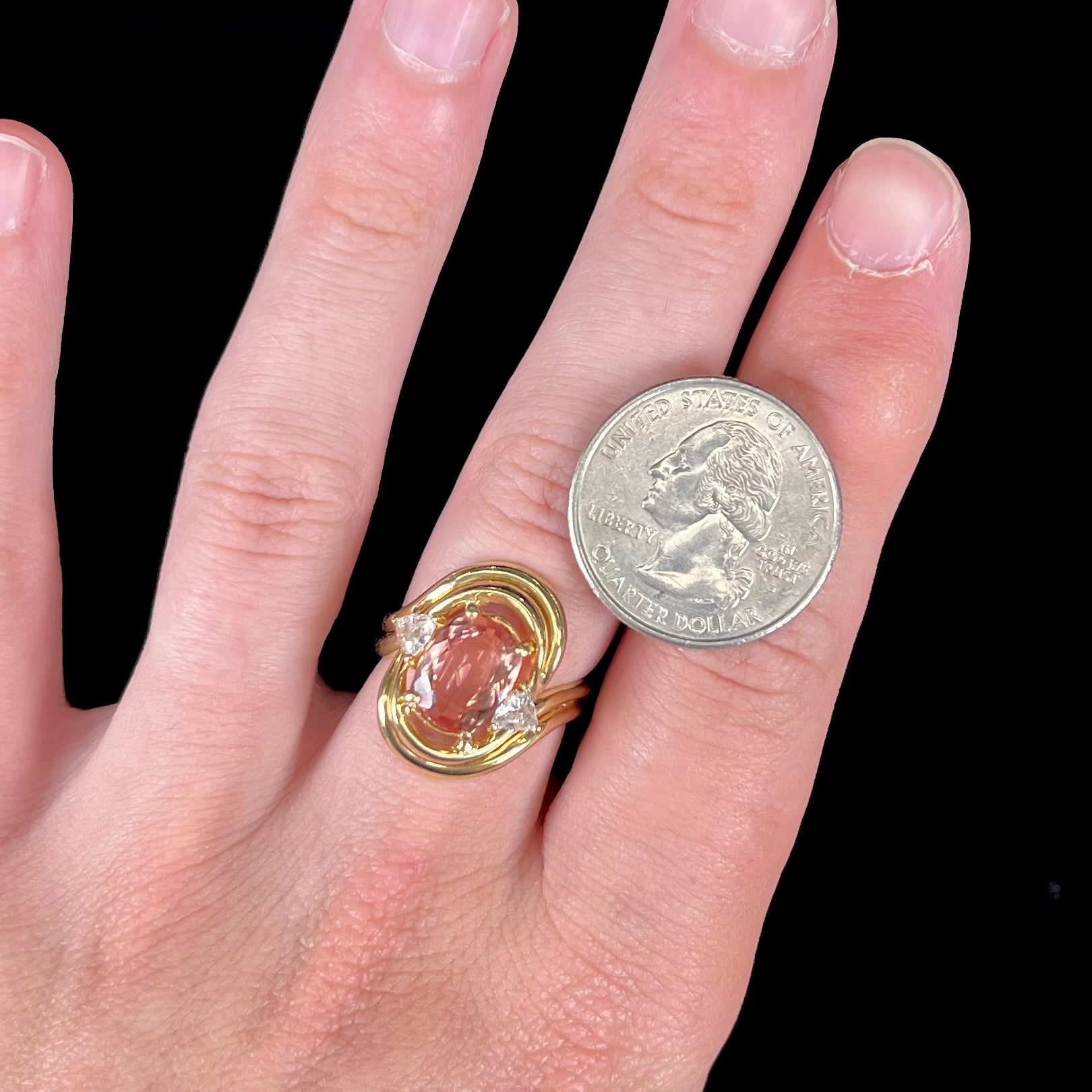 An 18 karat yellow gold ring set with two triangle cut diamonds and a cushion cut imperial topaz.