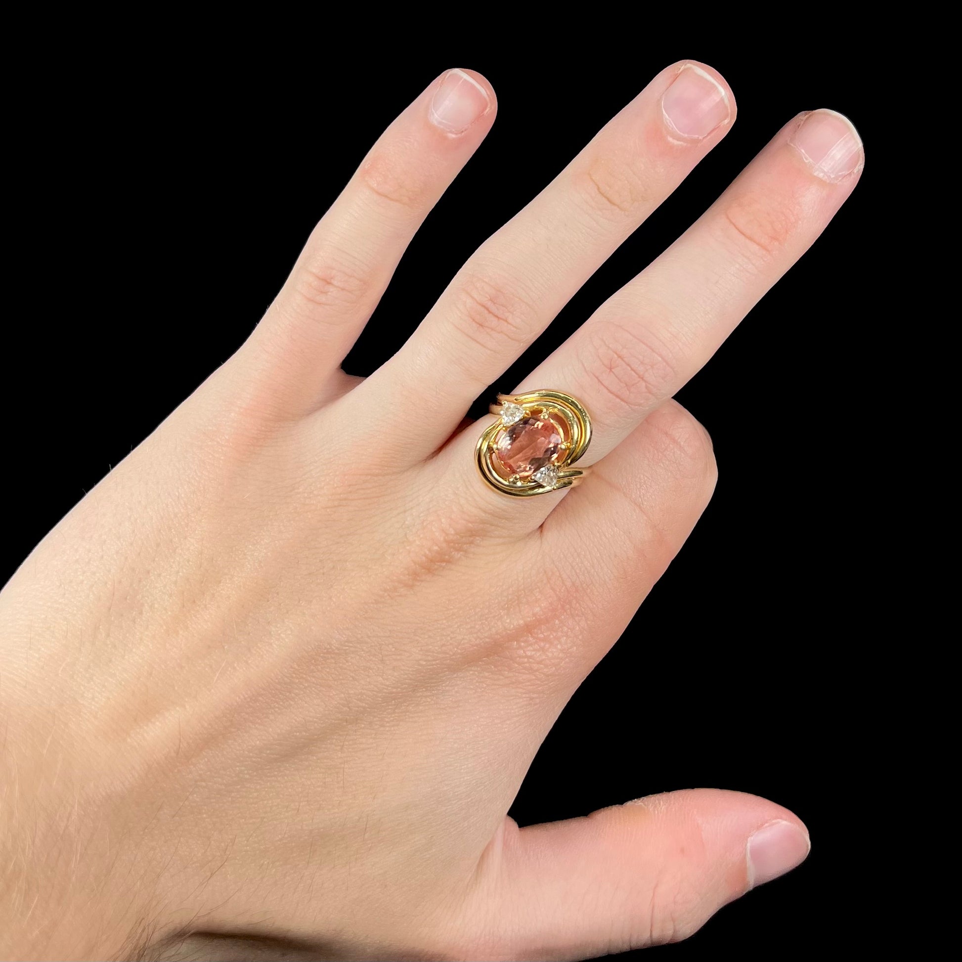 An 18 karat yellow gold ring set with two triangle cut diamonds and a cushion cut imperial topaz.