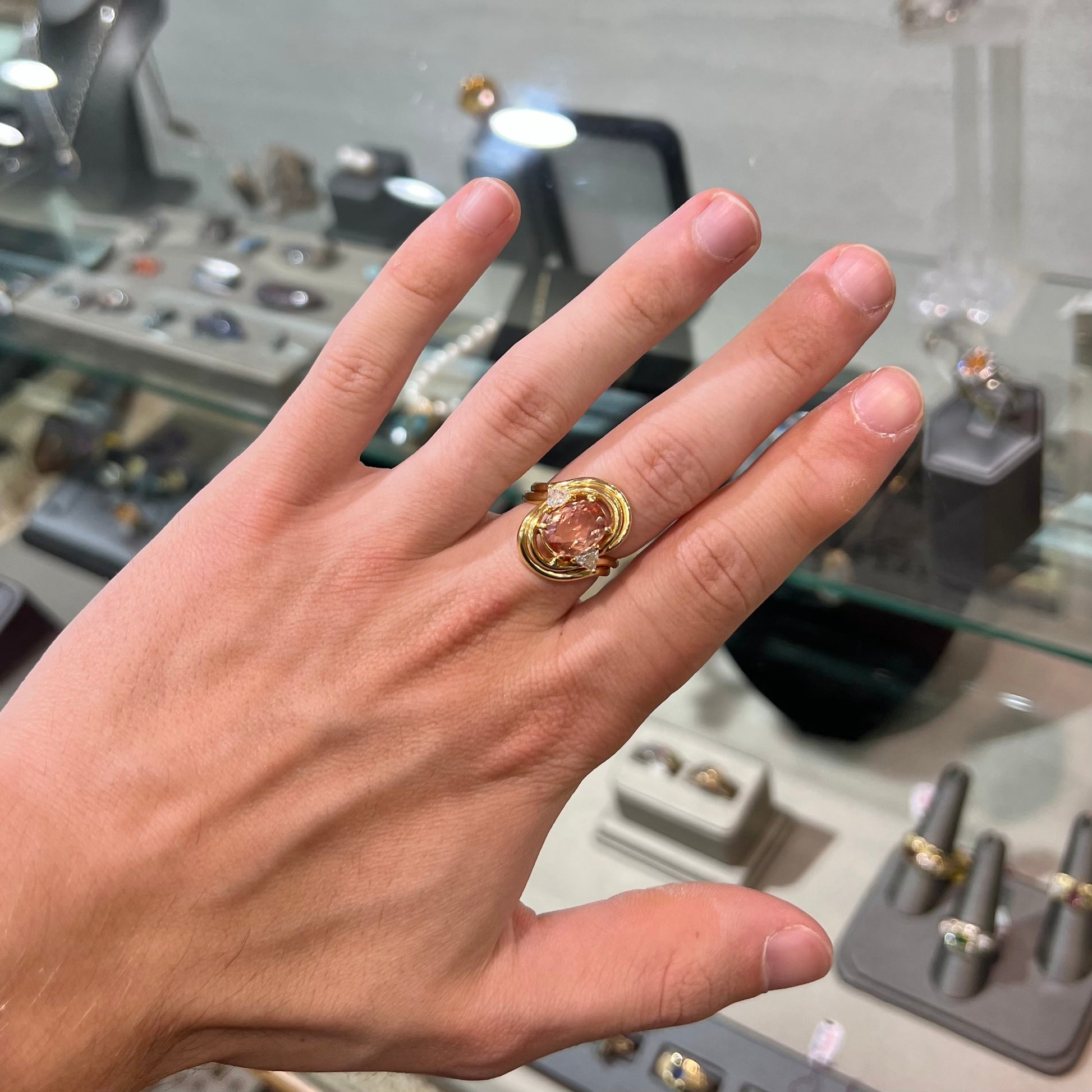 An 18 karat yellow gold ring set with two triangle cut diamonds and a cushion cut imperial topaz.