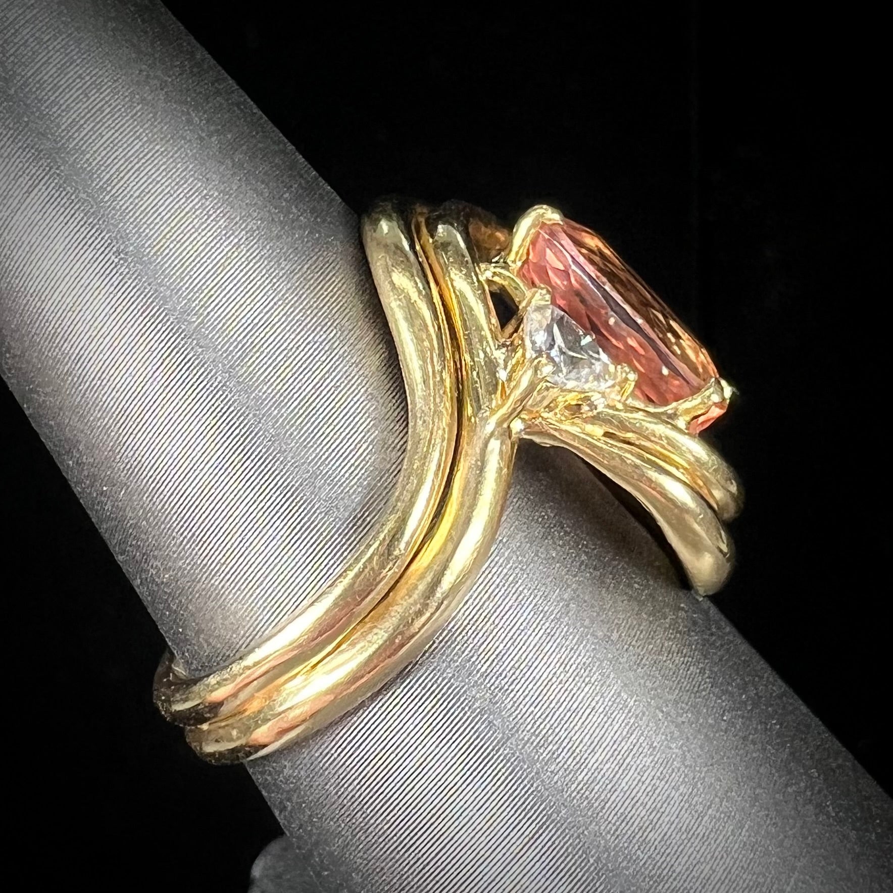 An 18 karat yellow gold ring set with two triangle cut diamonds and a cushion cut imperial topaz.