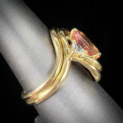 An 18 karat yellow gold ring set with two triangle cut diamonds and a cushion cut imperial topaz.
