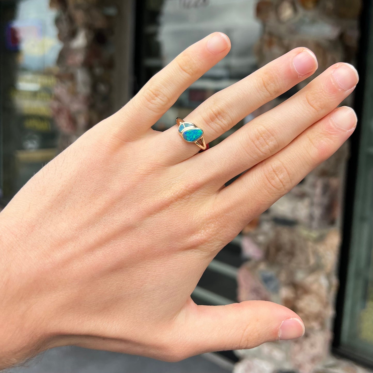 A ladies' black opal inlay ring cast in yellow gold.