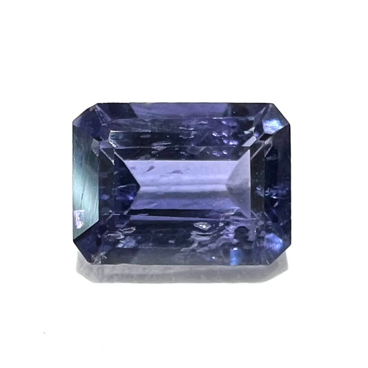 A loose, emerald cut blue iolite gemstone.