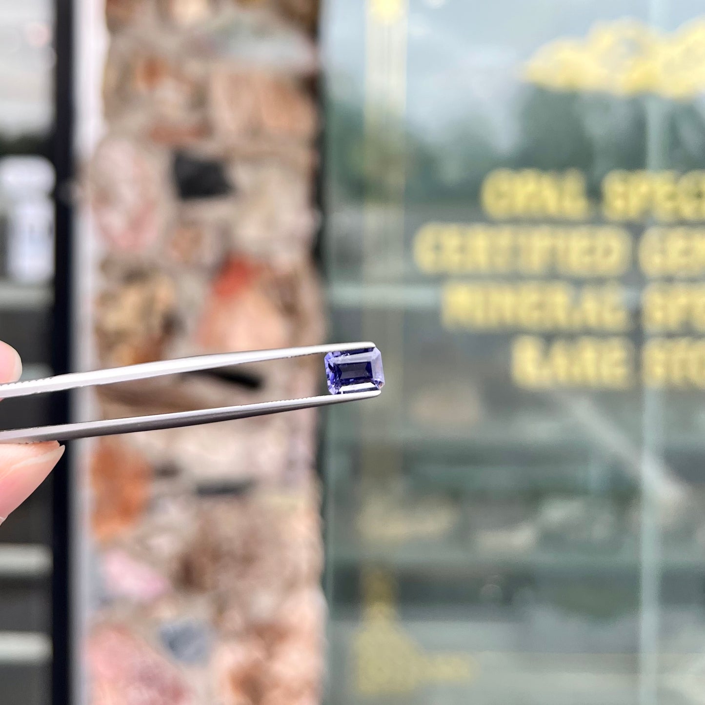 A loose, emerald cut blue iolite gemstone.