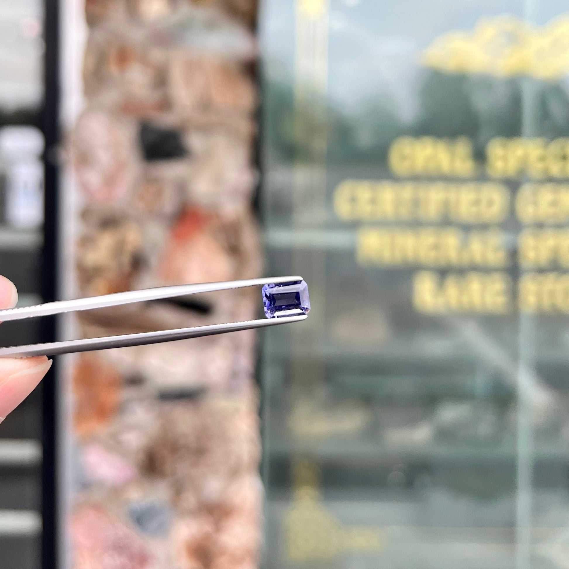 A loose, emerald cut blue iolite gemstone.