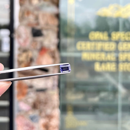 A loose, emerald cut blue iolite gemstone.
