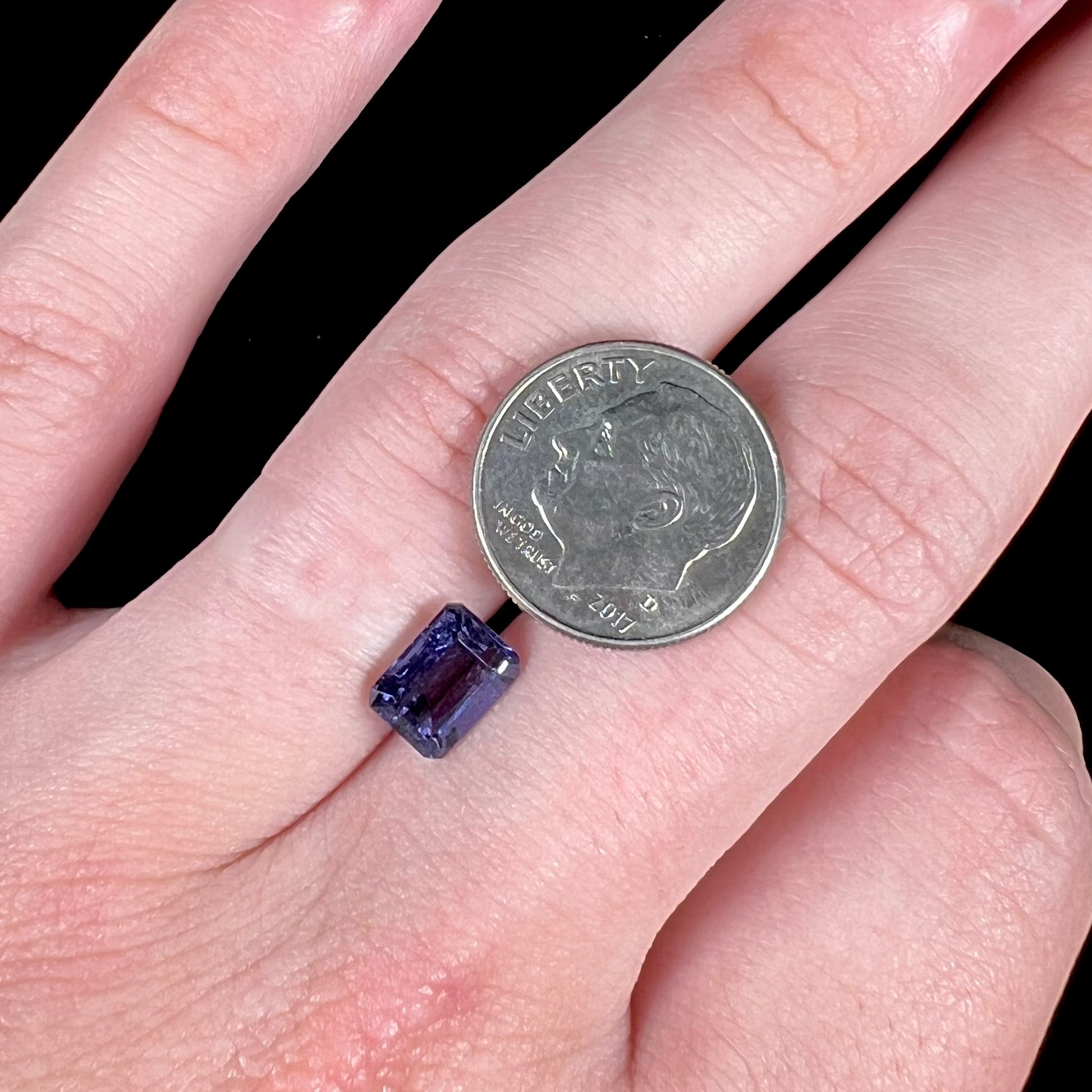 A loose, emerald cut blue iolite gemstone.